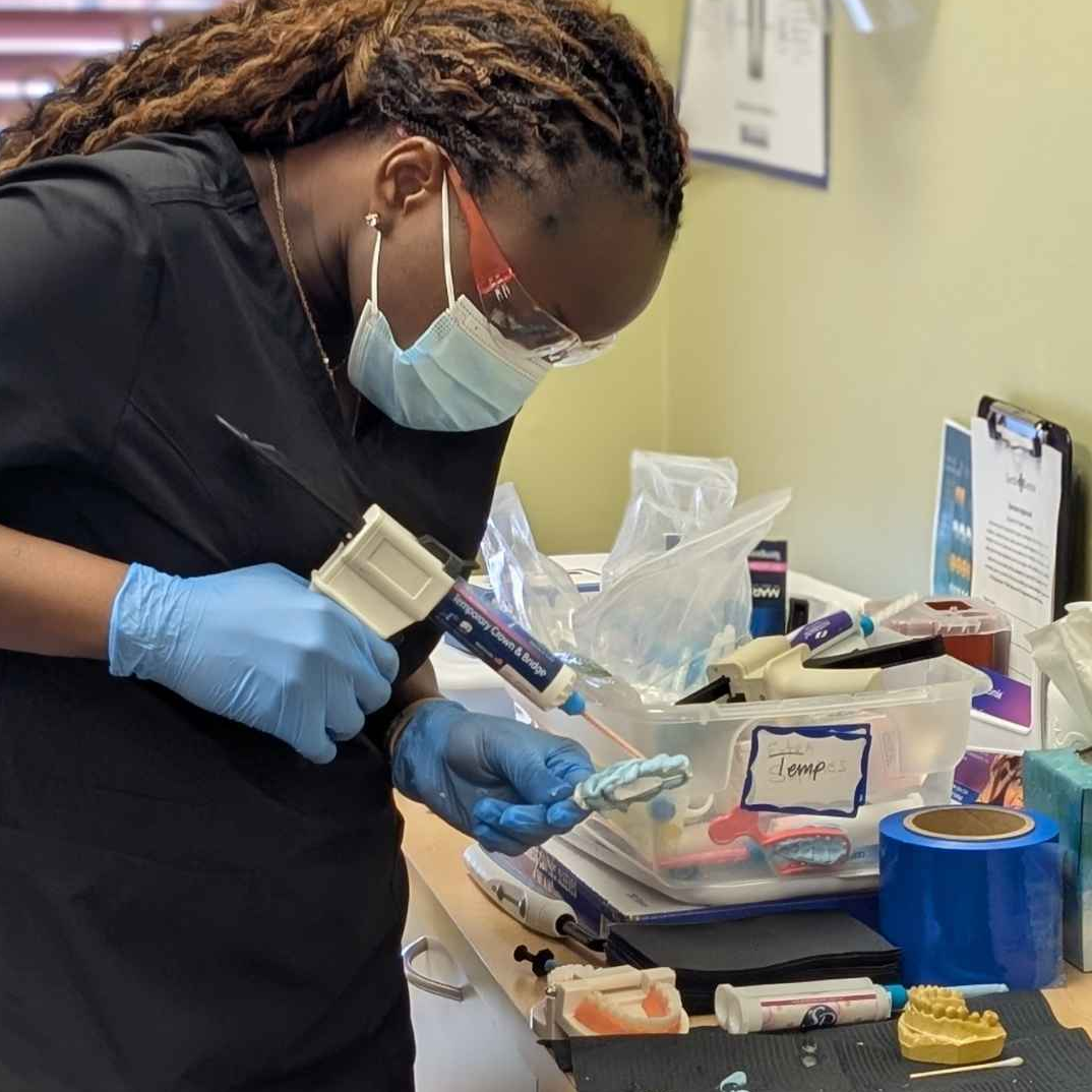 Dental assistant preparing clinical instruments in a modern dental clinic.